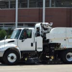 Tymco 600 Sweeper truck driving on roadway